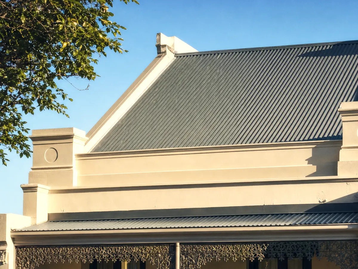 A Newcastle inner-city terrace, low-pitch steel roof set behind a rendered parapet with a box gutter along its line